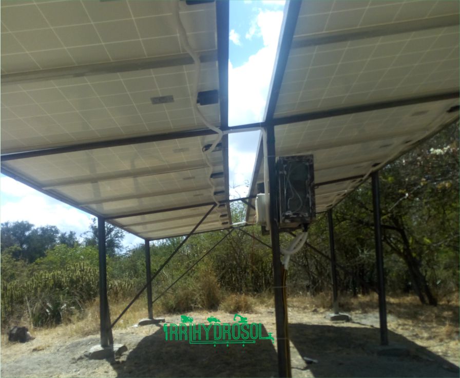 A high-efficiency solar panel set up to power a submersible borehole pump, ideal for off-grid water supply